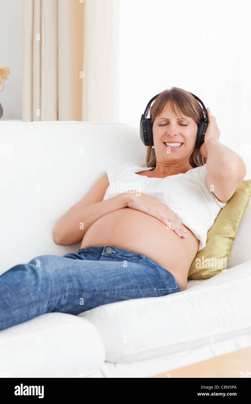 Portrait of a pregnant woman listening to music Stock Photo - Alamy