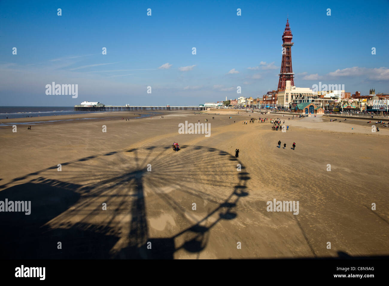 Shadow of the fairground ferris wheel on the beach with Blackpool beach and promenade in the background Stock Photo
