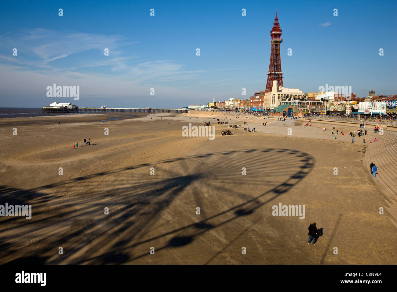 Shadow of the fairground ferris wheel on the beach with Blackpool beach and promenade in the background Stock Photo