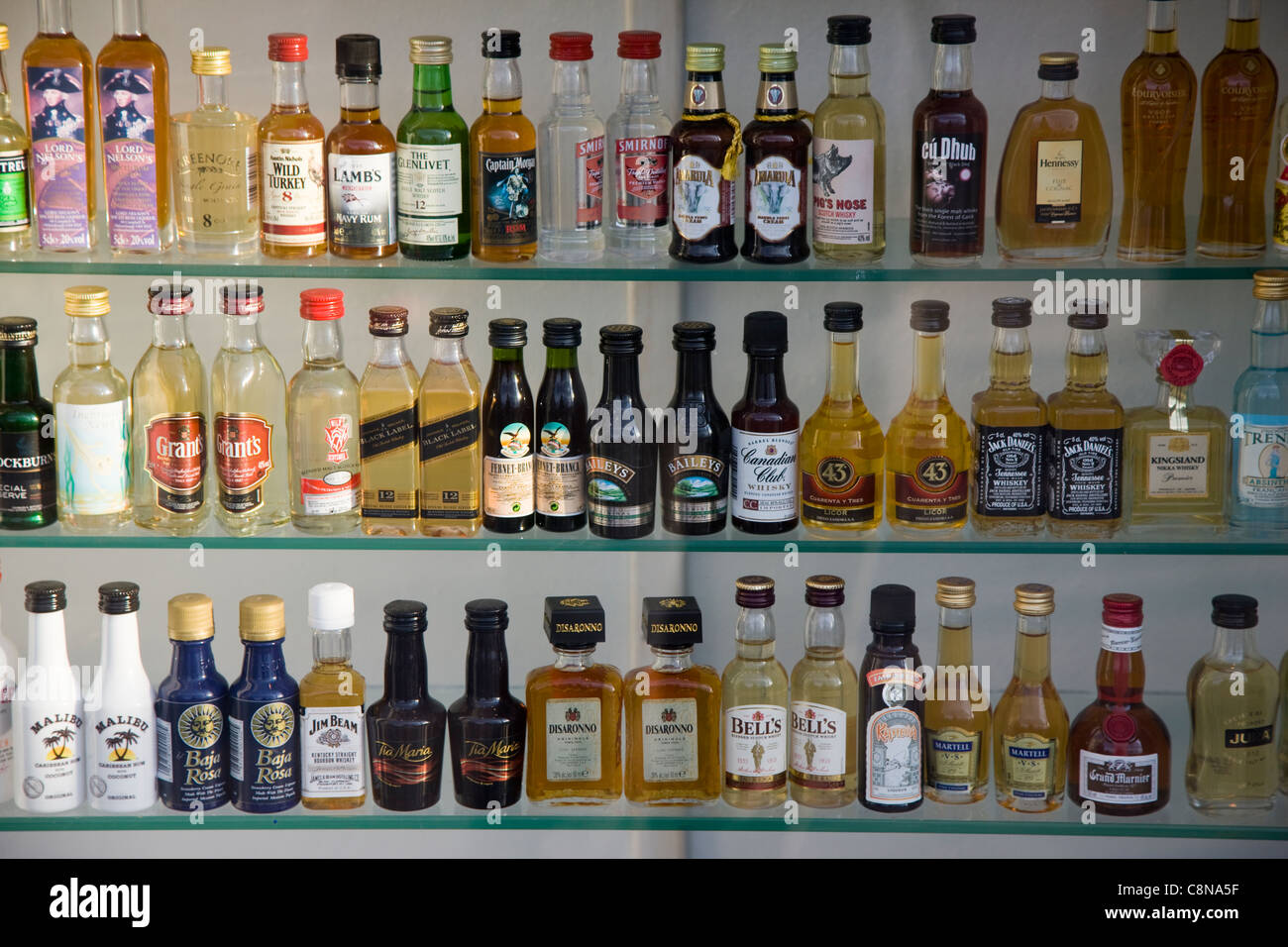Miniature bottles of whisky, brandy, vodka, cognac, gin, and other types of alcohol in a shop window, Blackpool, UK Stock Photo