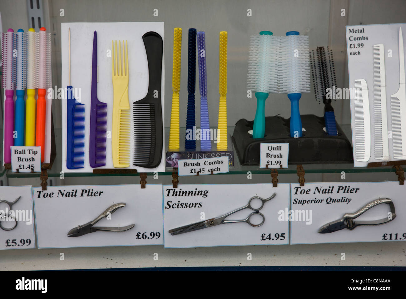 Hair brushes, clippers, scissors and other hairdressing equipment in a chemist's window in Blackpool, UK Stock Photo
