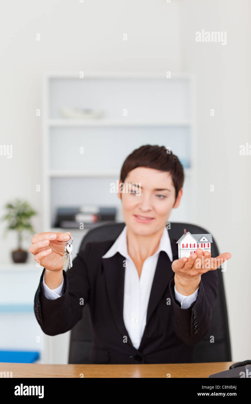 Portrait of a woman showing a miniature house and a key Stock Photo - Alamy