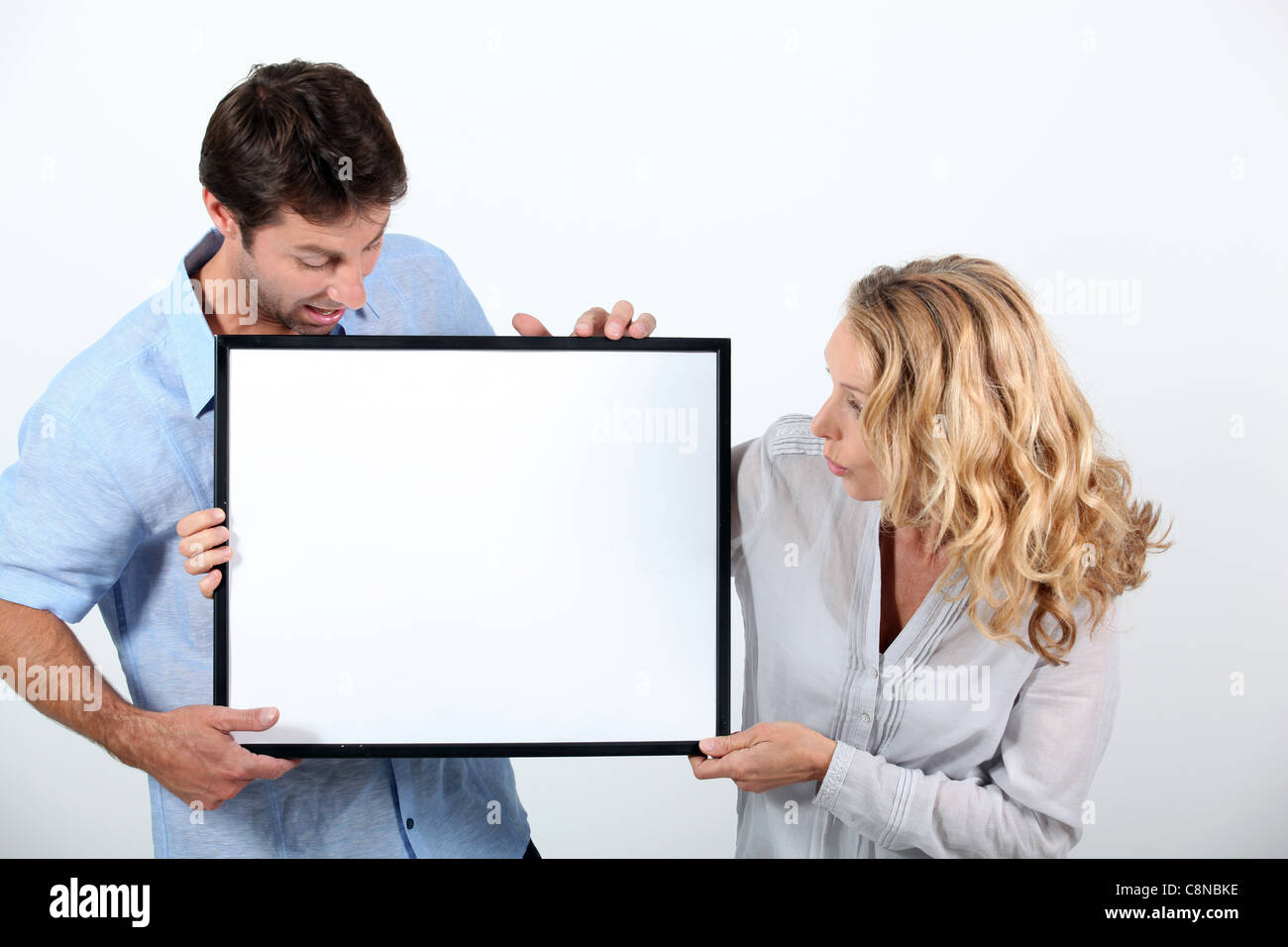 Man and woman astounded by a board left blank for your image Stock Photo