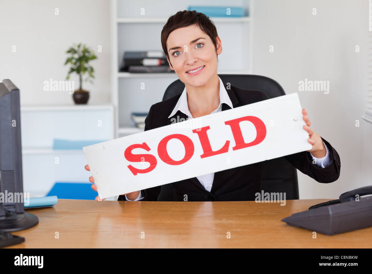 Happy real estate agent with a sold panel Stock Photo Alamy