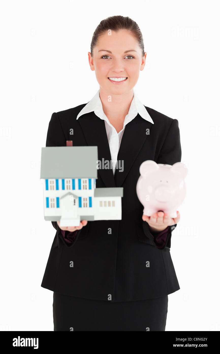 Pretty woman in suit holding a piggy bank and a miniature house Stock ...