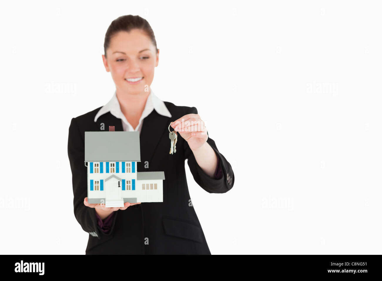 Charming woman in suit holding keys and a miniature house Stock Photo ...