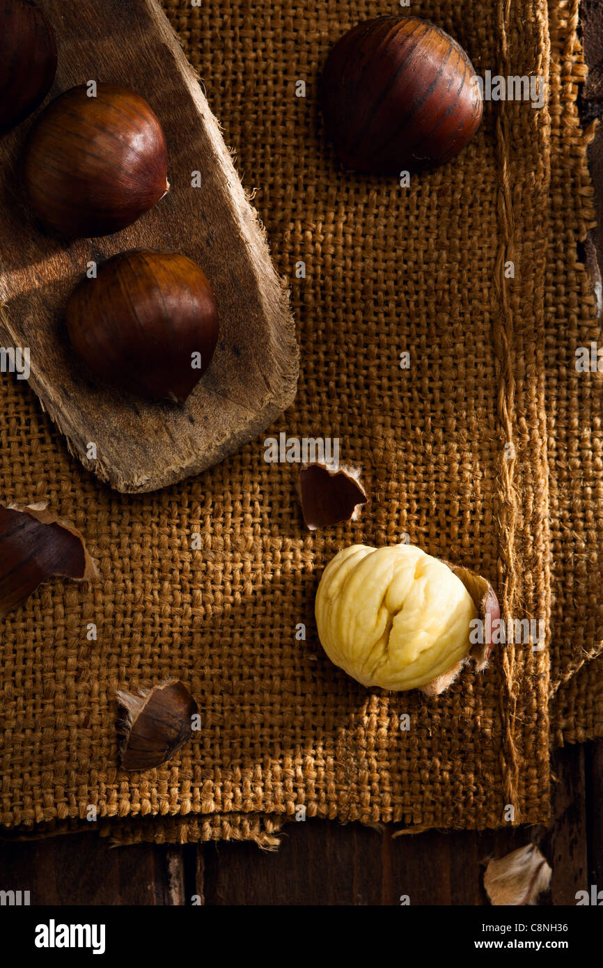 Raw Chestnuts on Jute and Wood Stock Photo