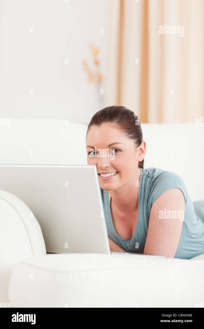 Beautiful woman relaxing with her laptop while lying on a sofa Stock ...