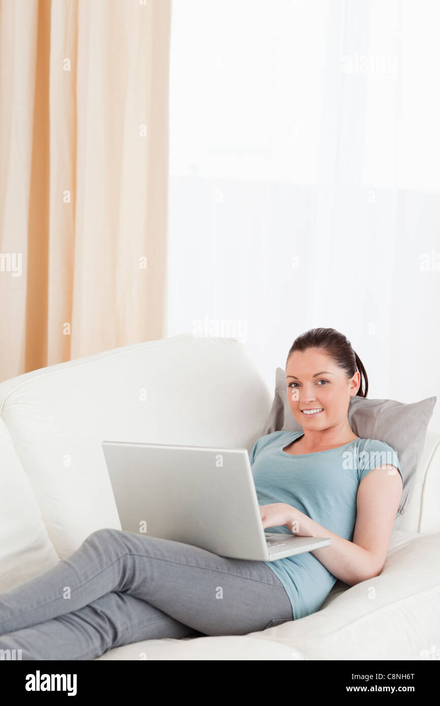 Gorgeous woman relaxing with her laptop while lying on a sofa Stock ...