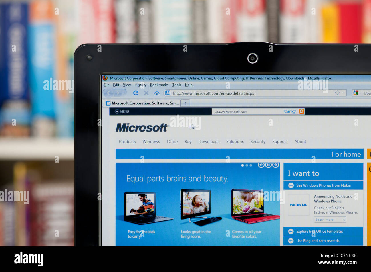 The Microsoft website shot against a bookcase background (Editorial use only: print, TV, e-book and editorial website). Stock Photo