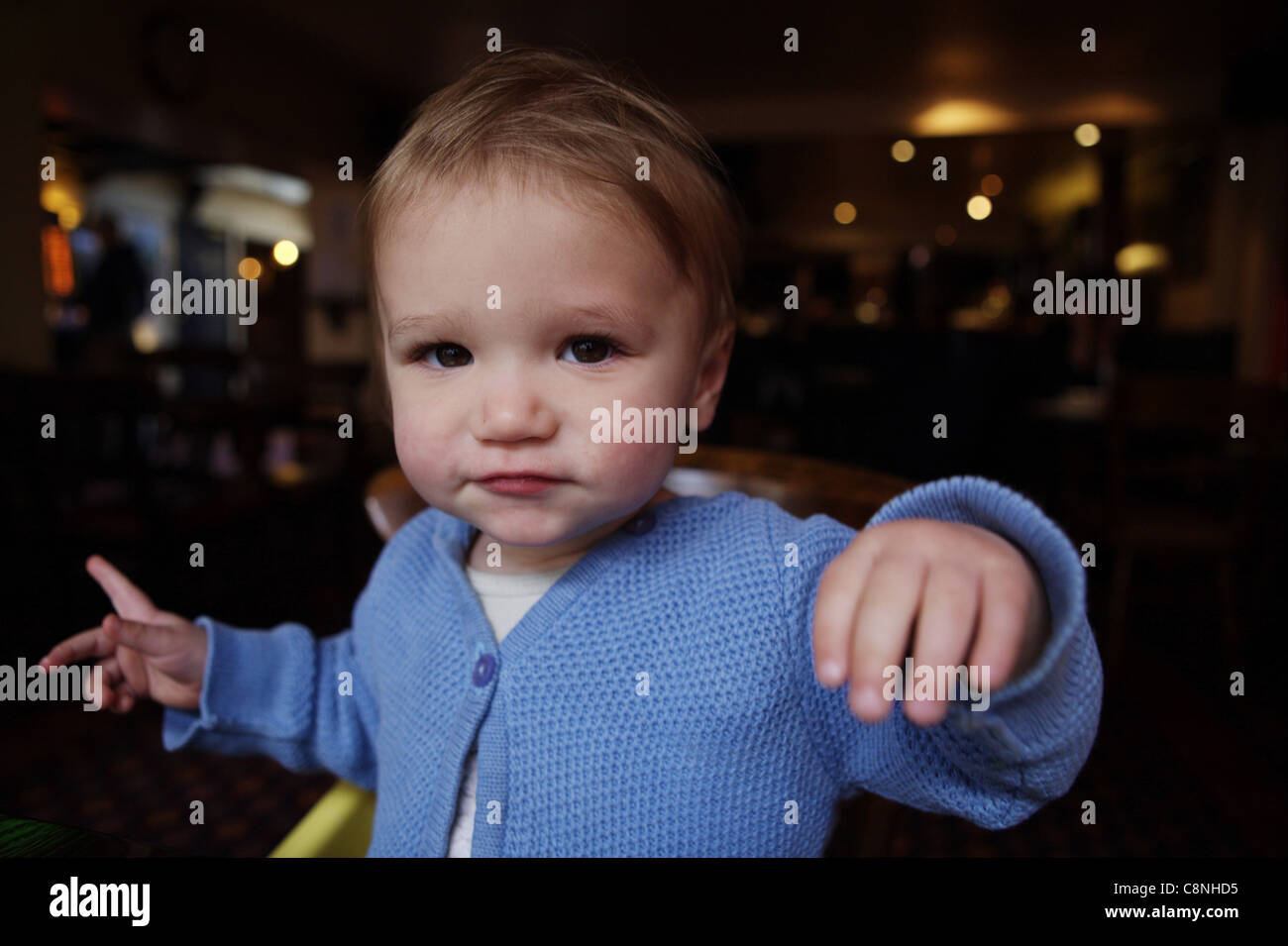 Young toddler in a blue cardigan in the Coach and Horses pub in