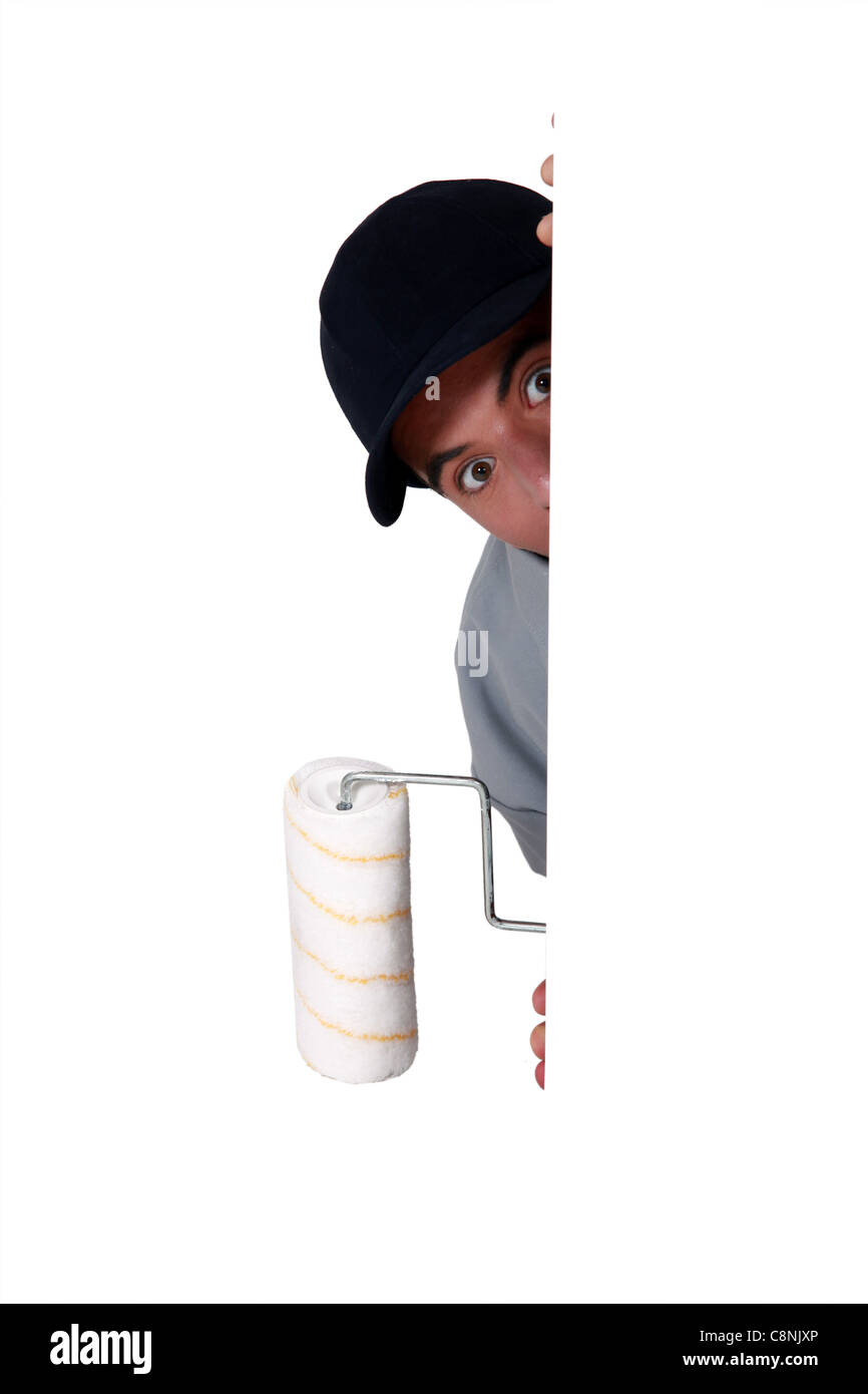 A male painter hiding behind a wall corner Stock Photo Alamy