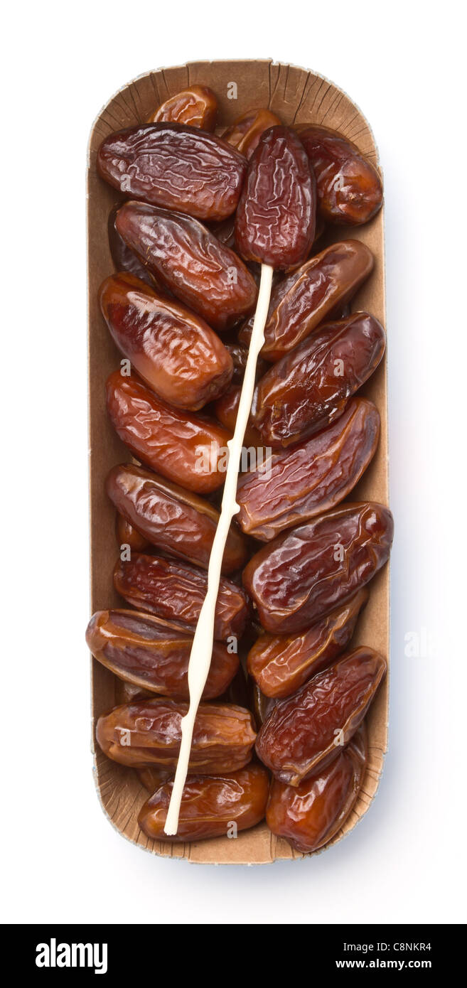 Cardboard tray of date fruits with skewer on white background. Stock Photo