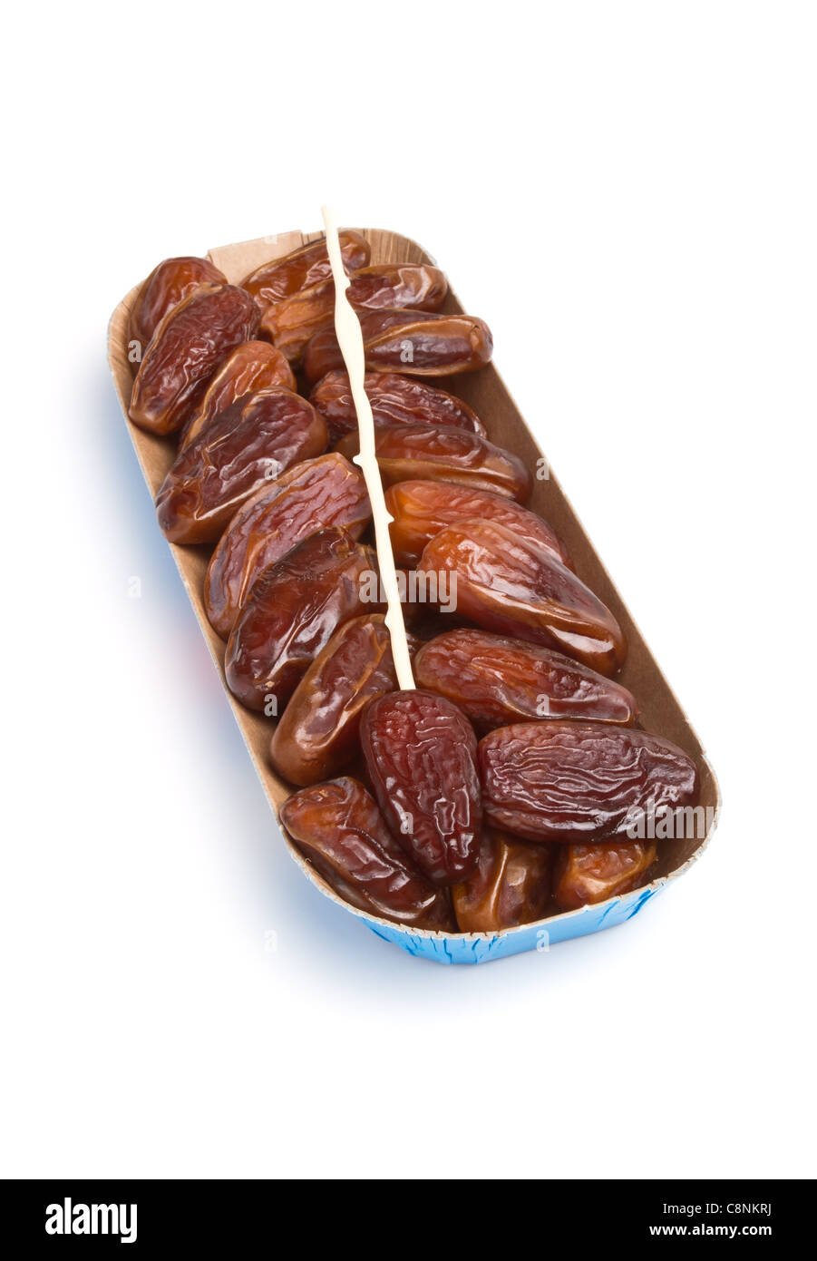 Cardboard tray of date fruits with skewer on white background. Stock Photo