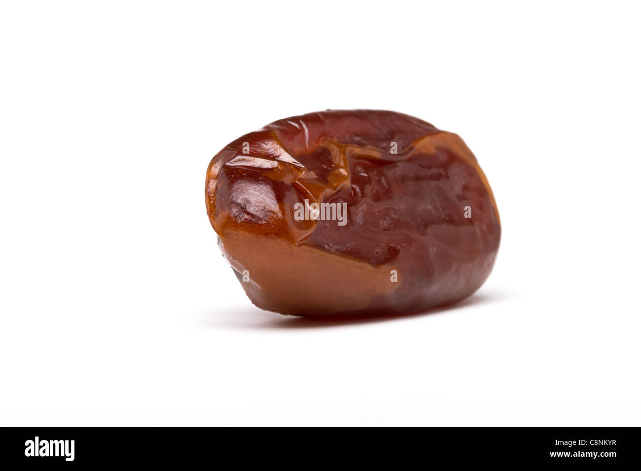 Single dried date fruit from low perspective with shallow focus. Stock Photo