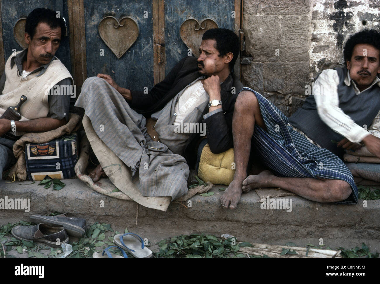 Three men chewing qat in a street in Sana' Yemen, 1980. Stock Photo