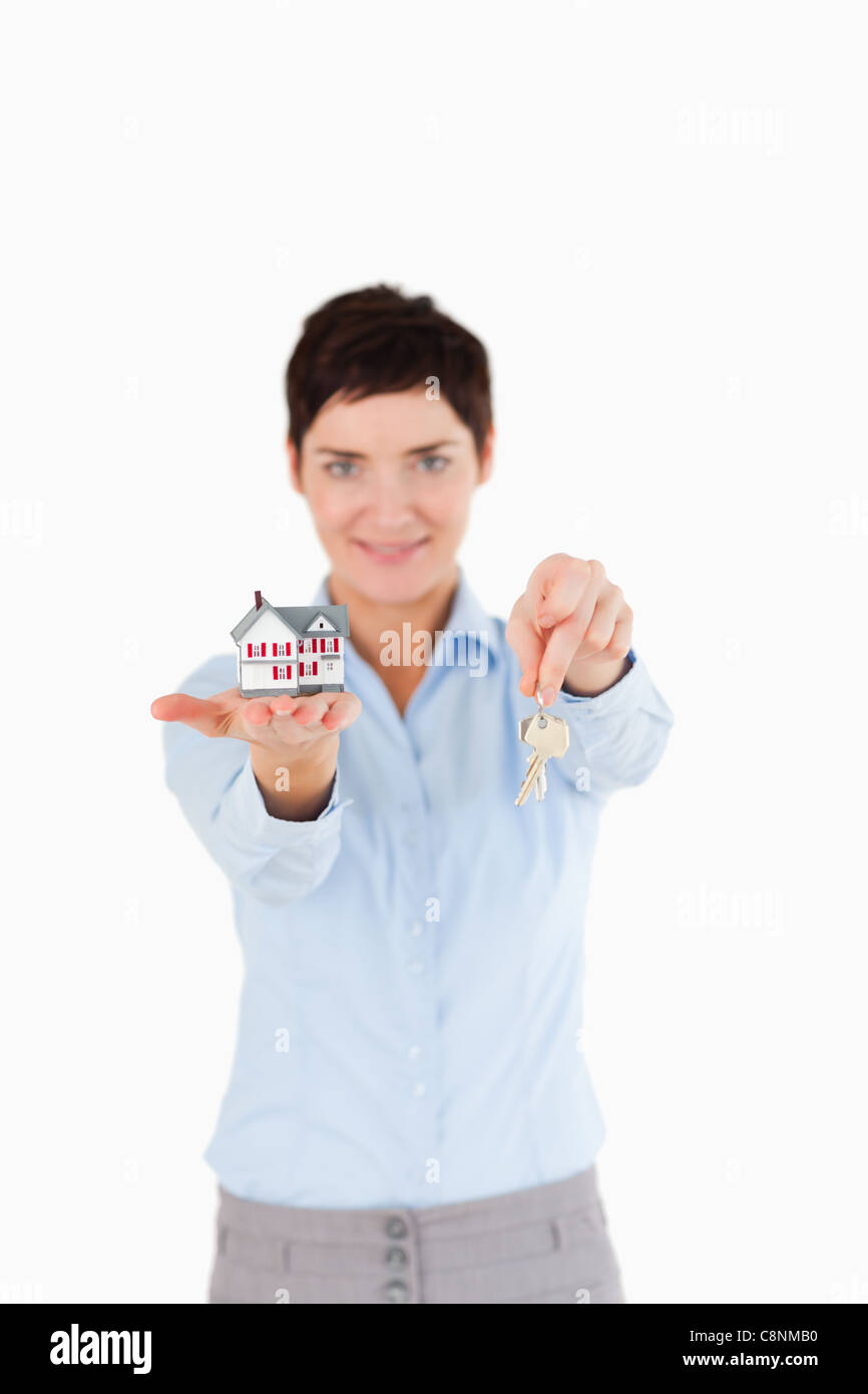 Woman showing keys and a miniature house Stock Photo - Alamy