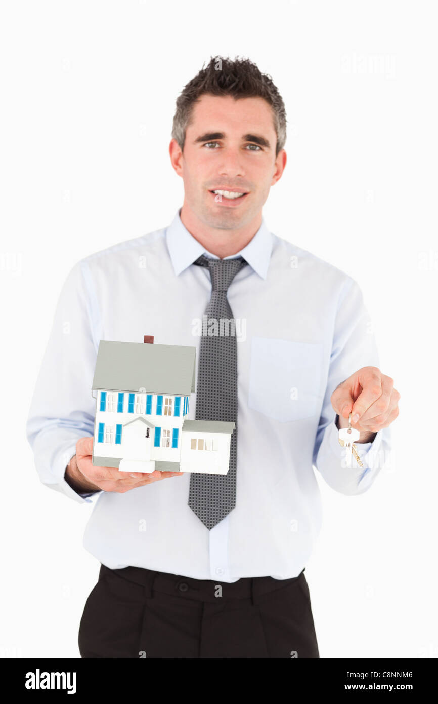 Man holding a key and a miniature house Stock Photo - Alamy