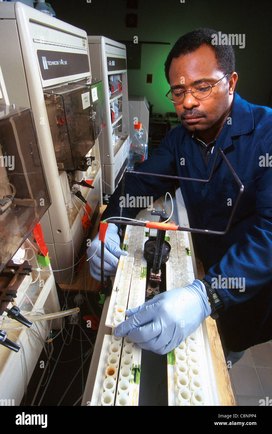 To determine nutrients in shallow ground water, chemist James Hill places water in an autosampler of the flow-through colorimetric autoanalyzer. Stock Photo