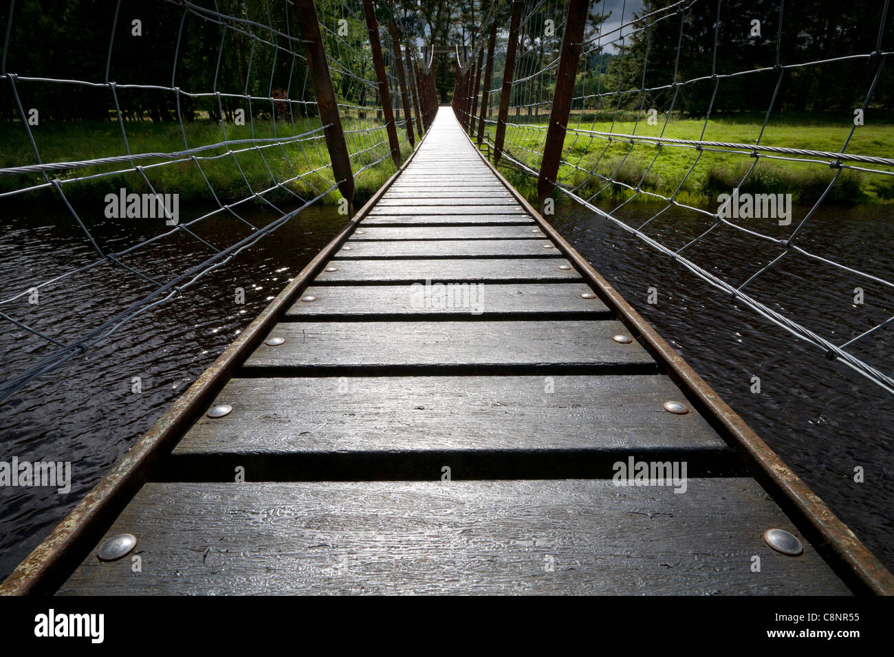 Low angle on a small suspension swing bridge over the river Lowther, Cumbria England Stock Photo