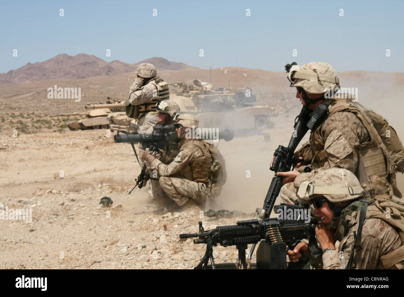 Supported by M1A1 Abrams tanks from 1st Tank Battalion, 1st Marine Division, the infantrymen of 2nd Platoon, Company F, 2nd Battalion, 25th Marine Regiment, assault an enemy objective during a live-fire combined arms exercise Aug. 14 at Marine Corps Air Ground Combat Center in Twentynine Palms, Calif. Stock Photo