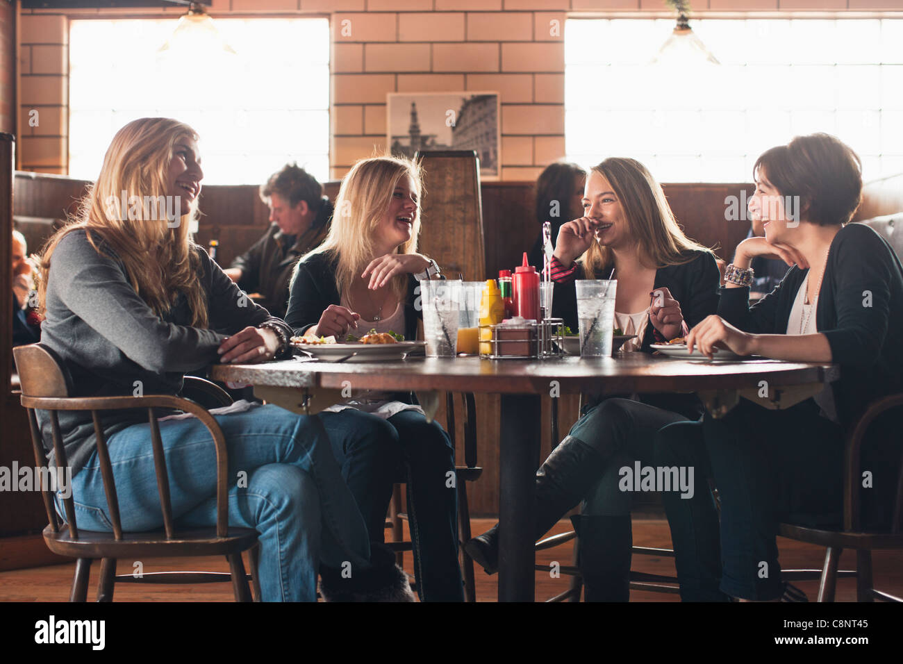 Caucasian teenagers eating together in restaurant Stock Photo