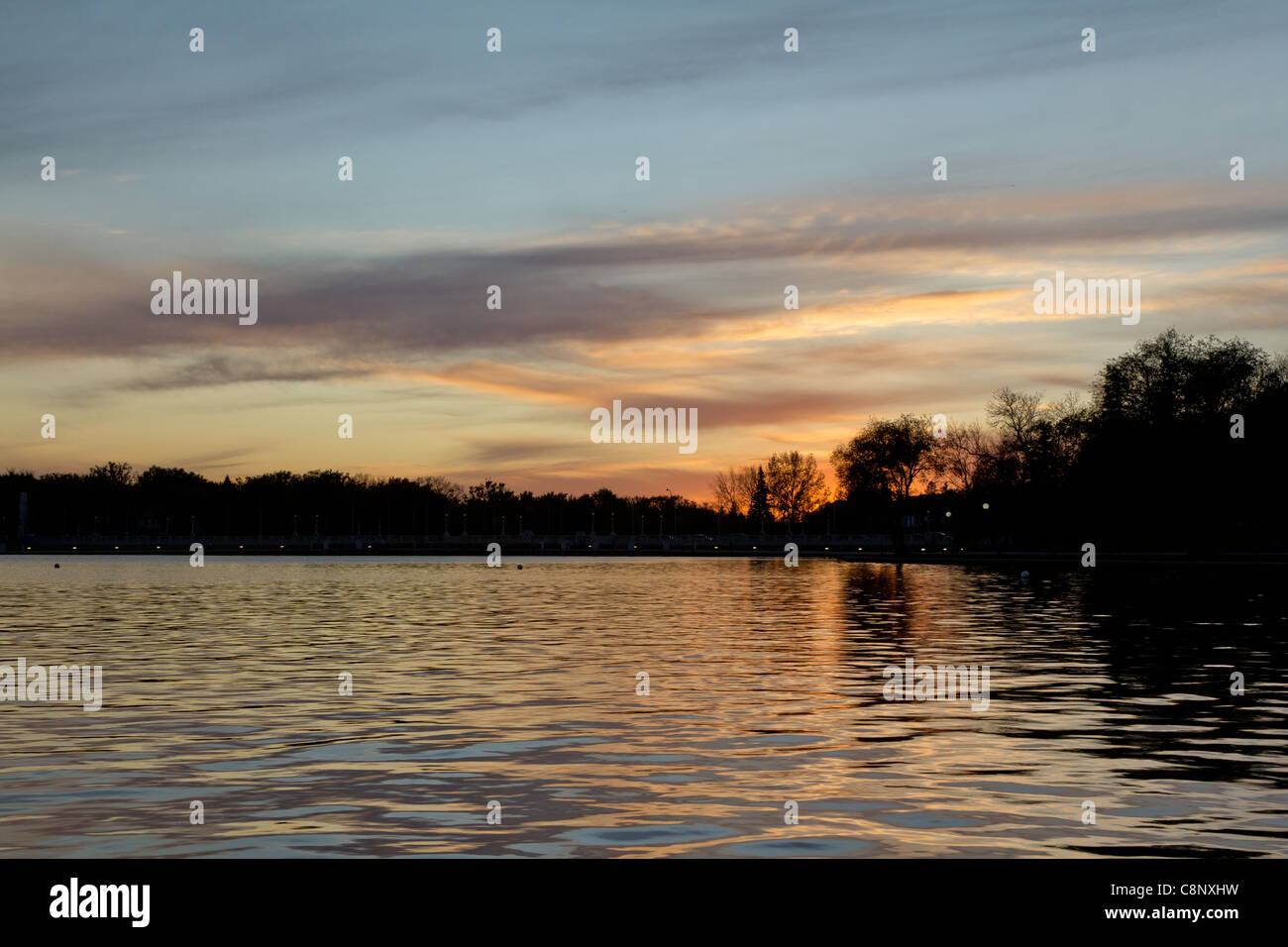 Beautiful sunset over lake Wascana with reflection of the sun on the water Stock Photo