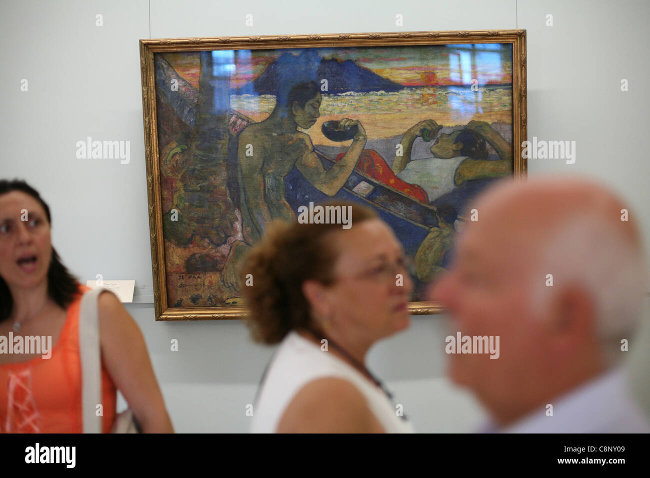 Canoe. Tahitian Family. Visitors in front of the painting by Paul Gauguin in the Hermitage Museum in St Petersburg, Russia. Stock Photo