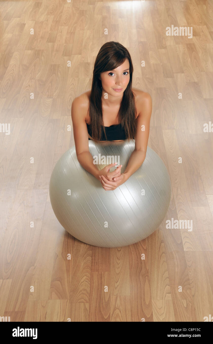 Gym dressed young woman posing with pilates fitball Stock Photo