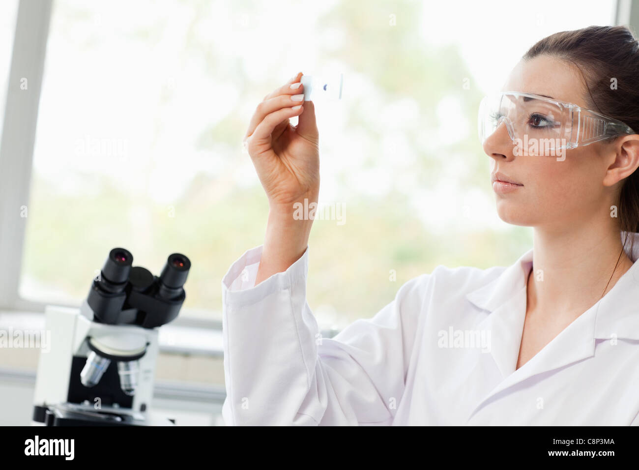 Beautiful science student looking at a microscope slide Stock Photo - Alamy