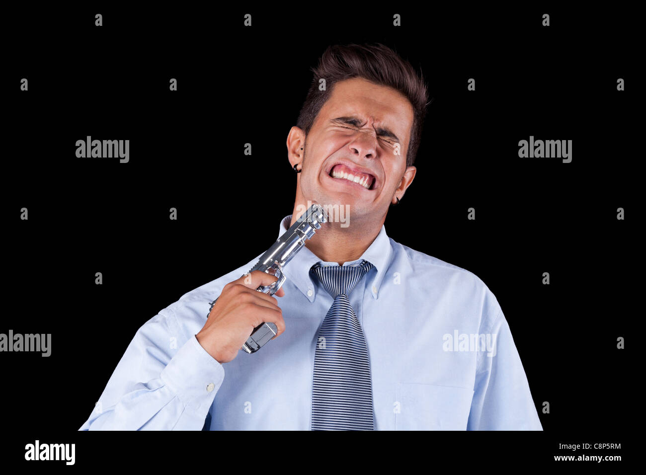 Stressed young businessman with a gun pointing to his head (isolated on