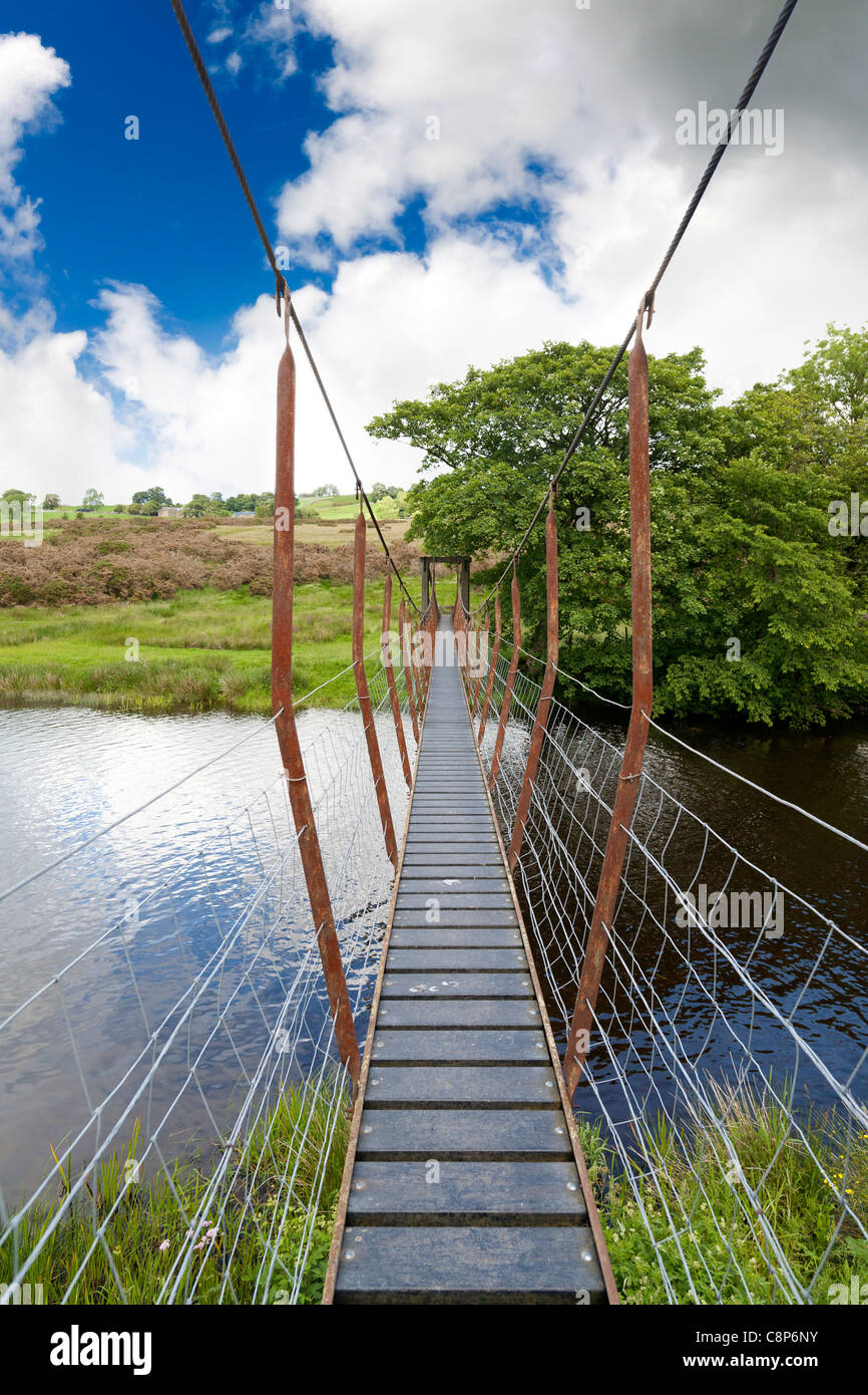 Looking along the length of a small suspension swing bridge over the river Lowther, Cumbria England Stock Photo