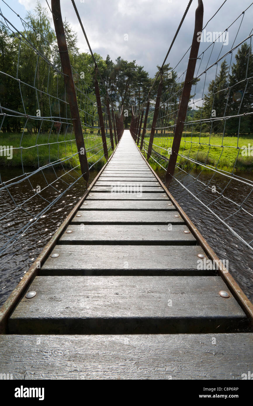 Low angle on a small suspension swing bridge over the river Lowther, Cumbria England Stock Photo