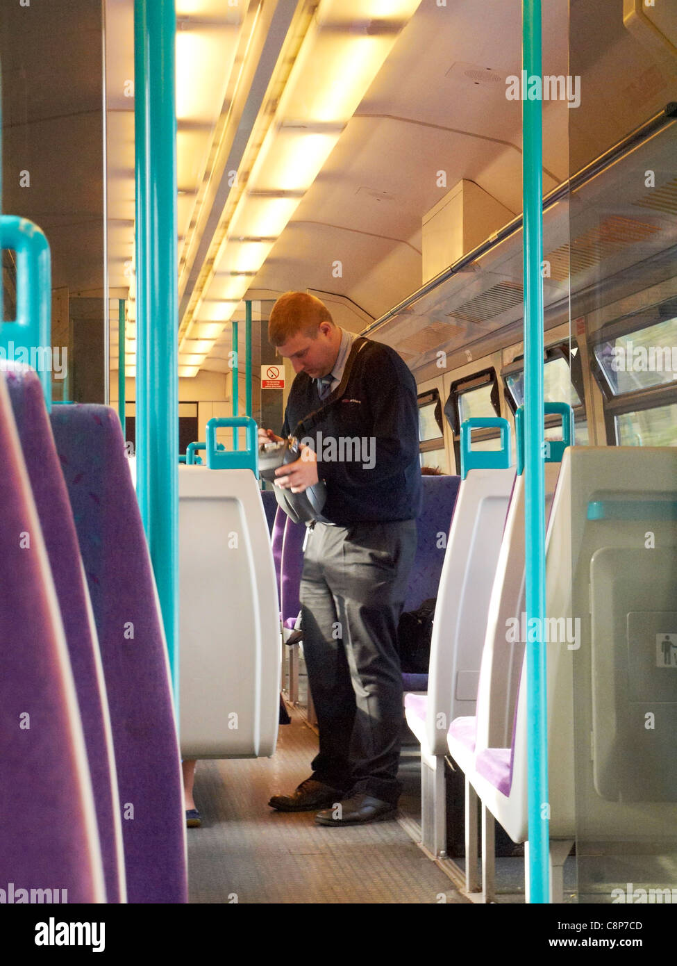 Train conductor collecting rail tickets on Northern Line UK Stock Photo