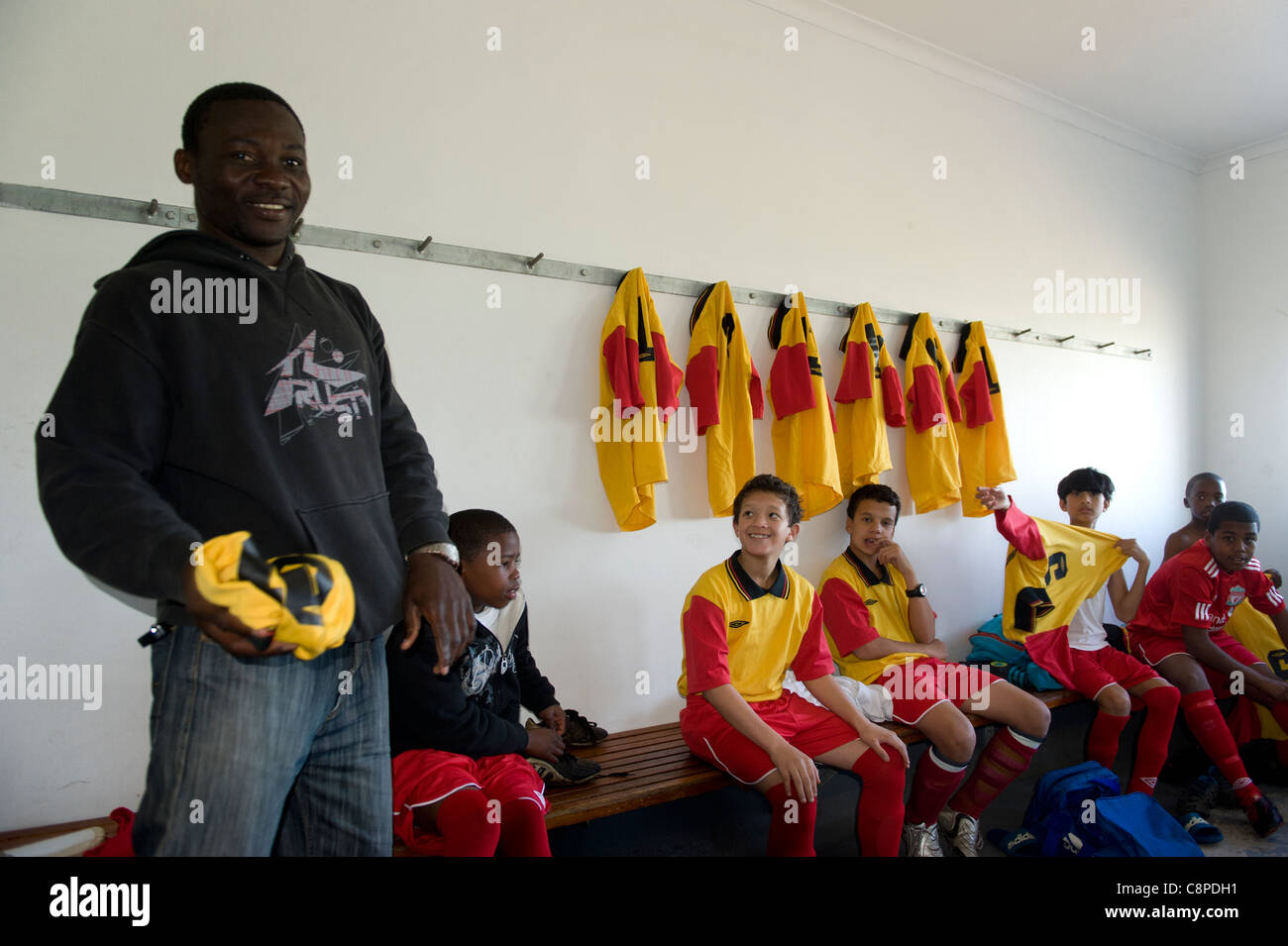 Football coach with junior team in the changing room Cape Town South Africa Stock Photo