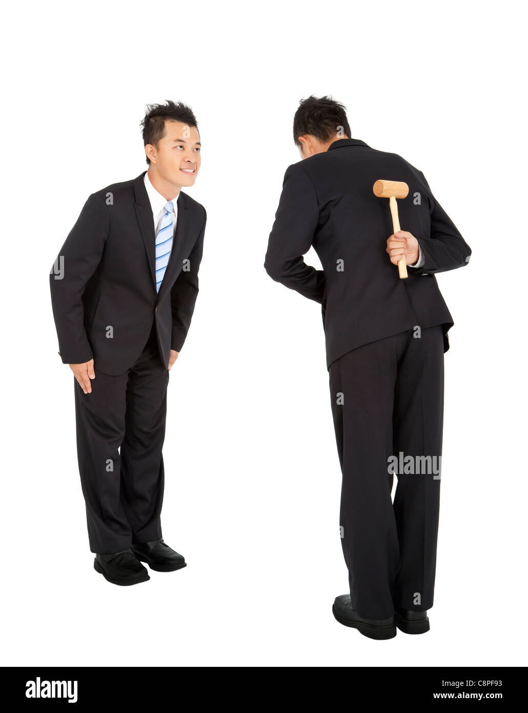 business competition concept.two asian businessman bowing and holding hammer behind Stock Photo