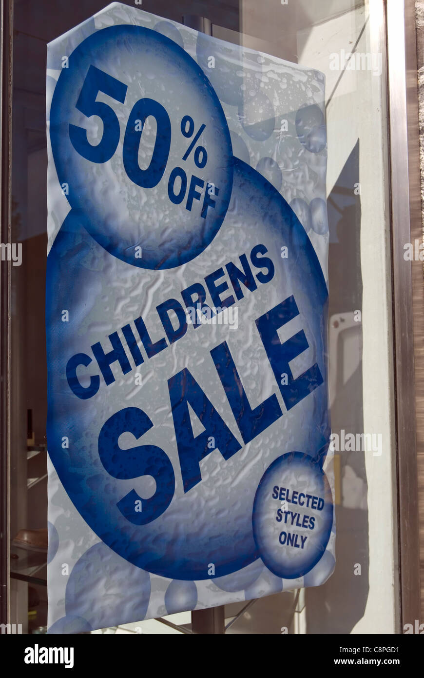 childrens sale 50 off sign in a shop window in new malden, surrey