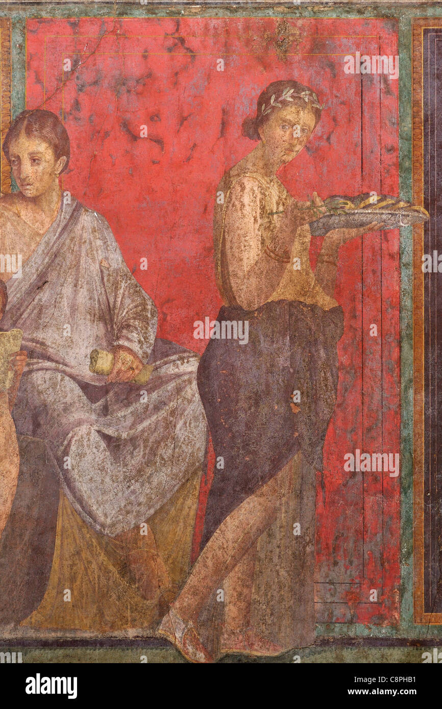 Pompei. Italy. Detail showing a young woman carrying a plate of food from the fresco in the Villa dei Misteri (Villa of the Mysteries) Pompeii. Stock Photo