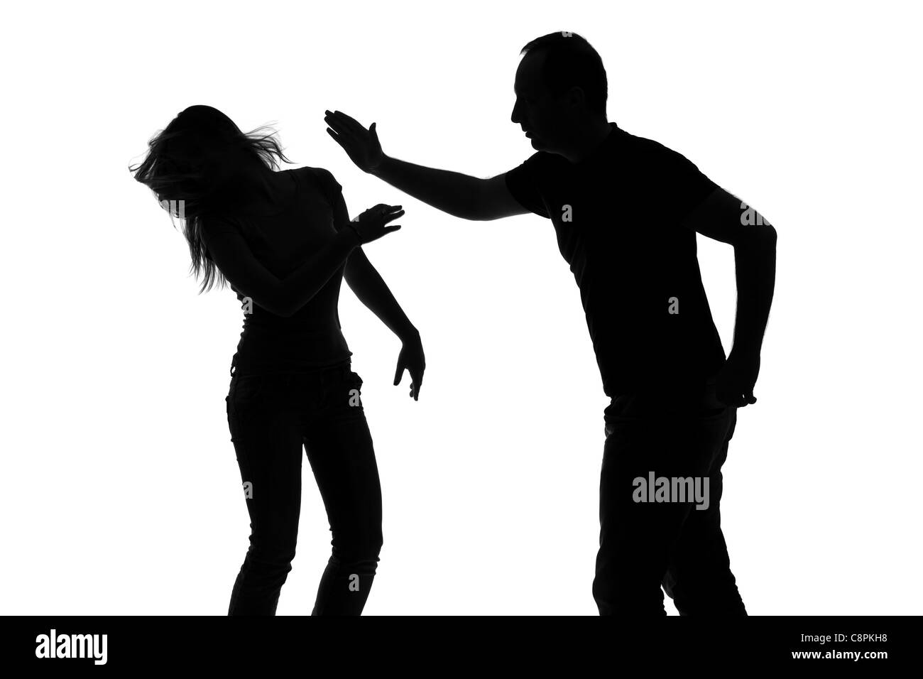 Silhouette of a man slapping a woman Stock Photo