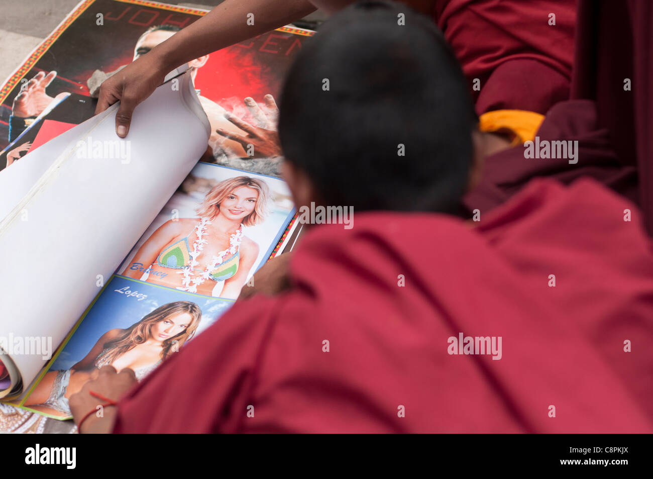 Young Buddhist monks view images of Britney Spears and Jennifer Lopez in their underwear. India. Stock Photo