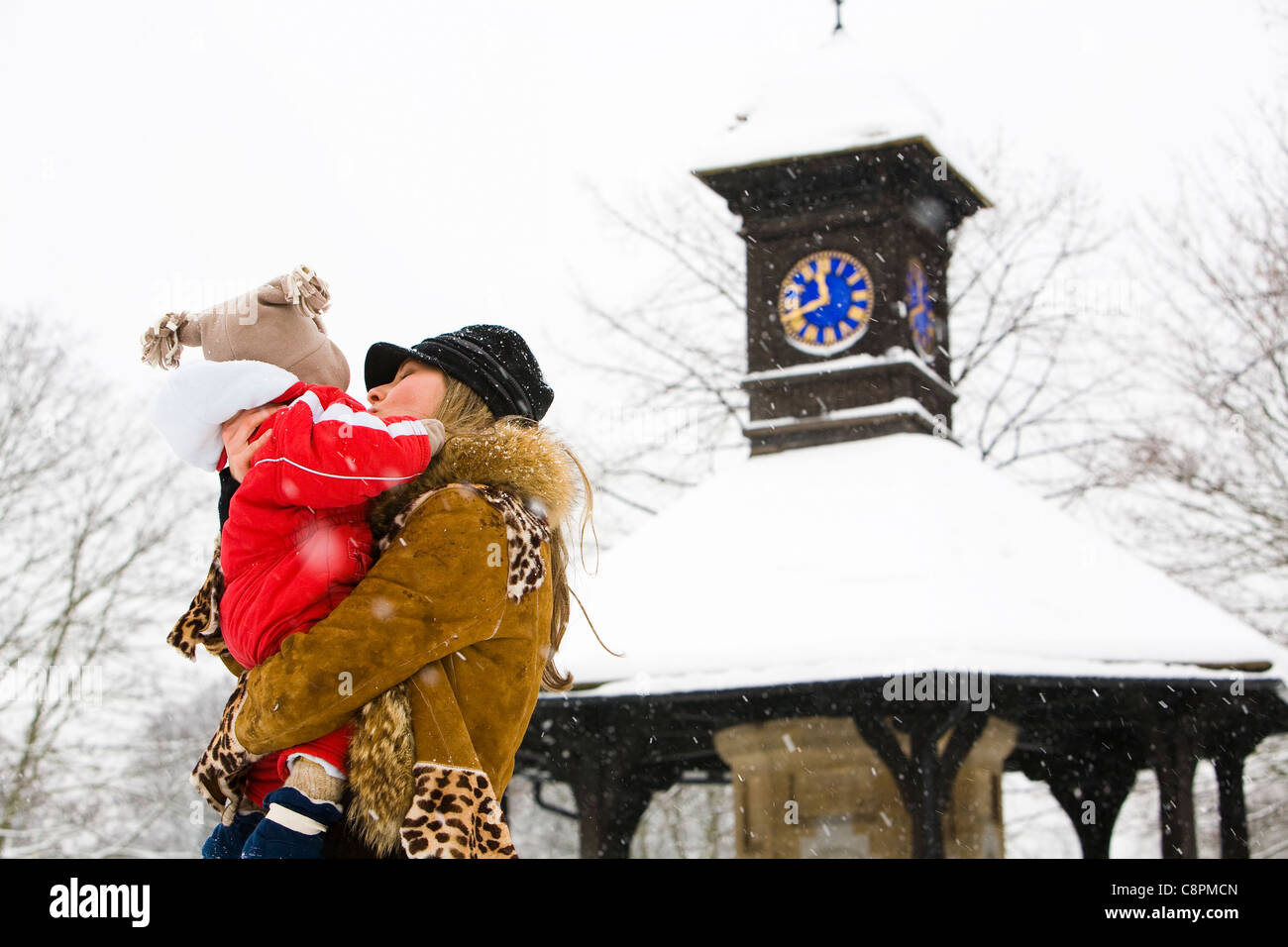Mum holding her son in Hyde park while snowing. Stock Photo