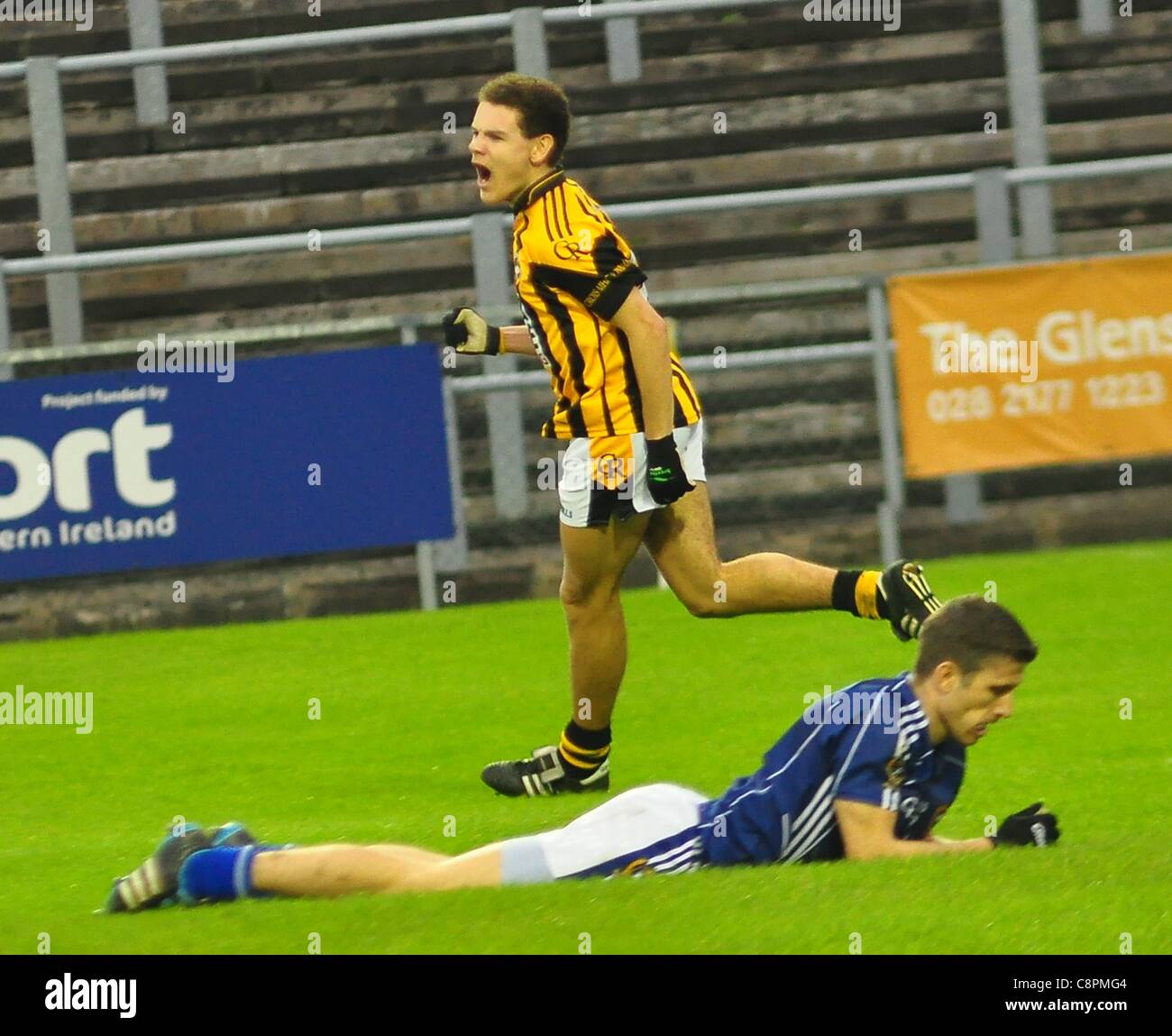 Crossmaglen's Aaron Cunningham runs past Saint Gall's Sean Kelly as he celebrates scoring Crossmaglen's second goal. Reigning Ulster and All Ireland Gaelic Football Champions Crossmaglen Rangers  defeat St Galls in the Ulster Club Football Quarter Final with a score line of 3-09 to 2-06 in Casement  Stock Photo