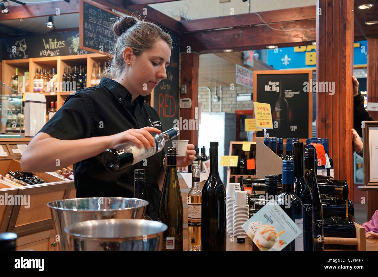 Young woman pouring wine sample for tasting Stock Photo