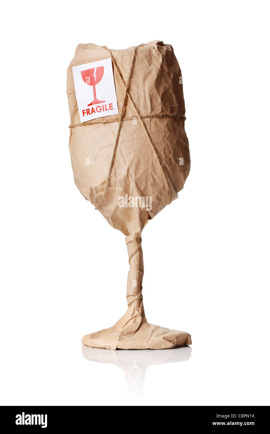 A Wine glass packaged in brown wrapping paper with 'Fragile' warning sticker. Stock Photo