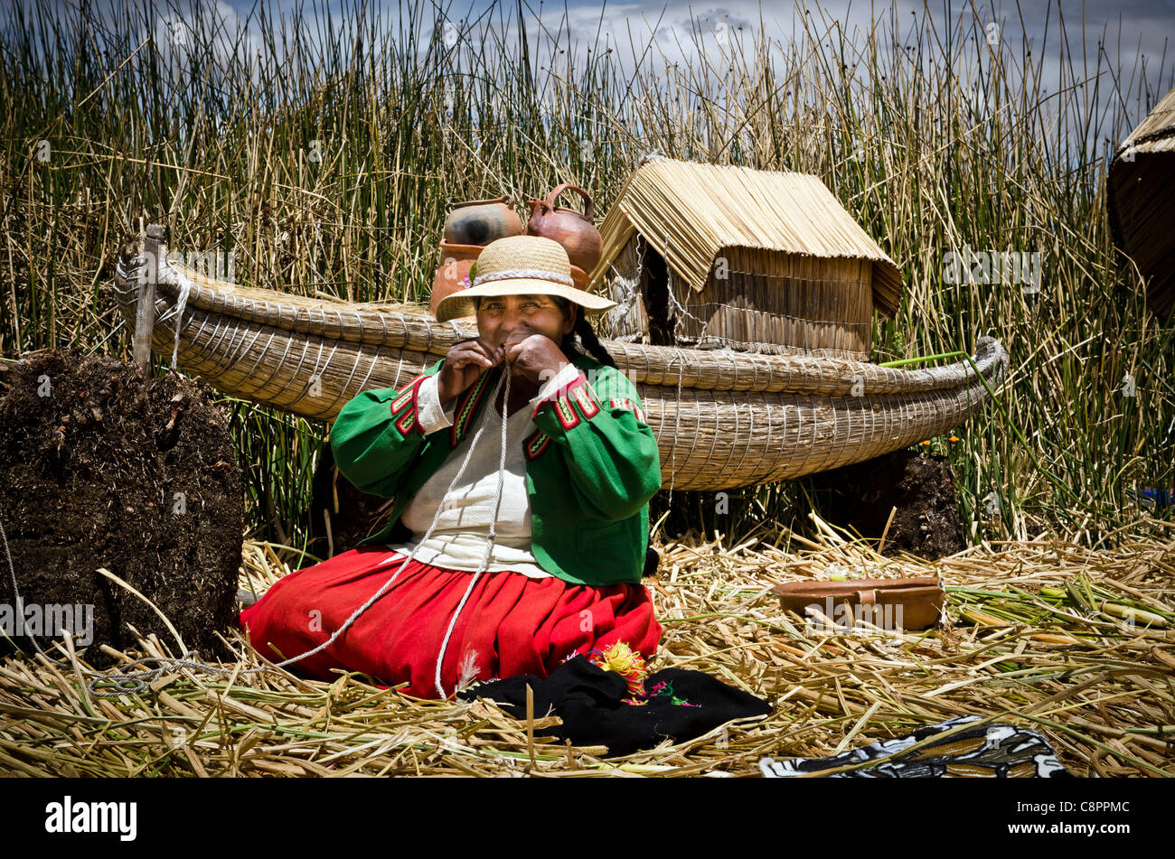 Woman in traditional peruvian costume making handcrafts Uros island Titicaca lake Puno Peru Stock Photo