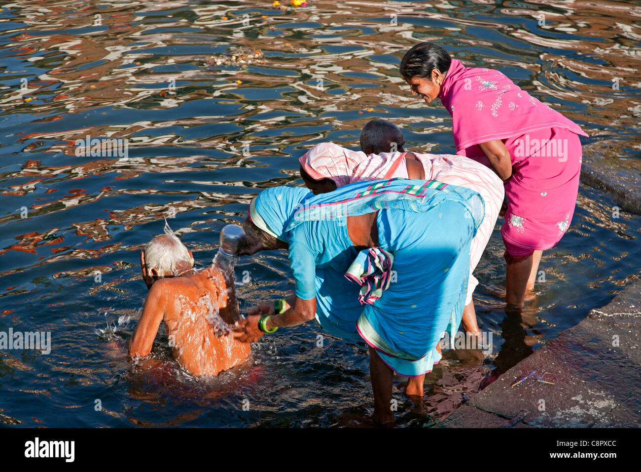 Women washing an elder relative (an hindu tradition). Ram Kund. Godavari river. Nashik. India Stock Photo