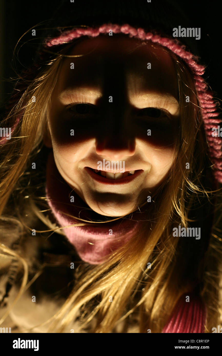 Ghost girl. Young girl lighting from bellow. Stock Photo