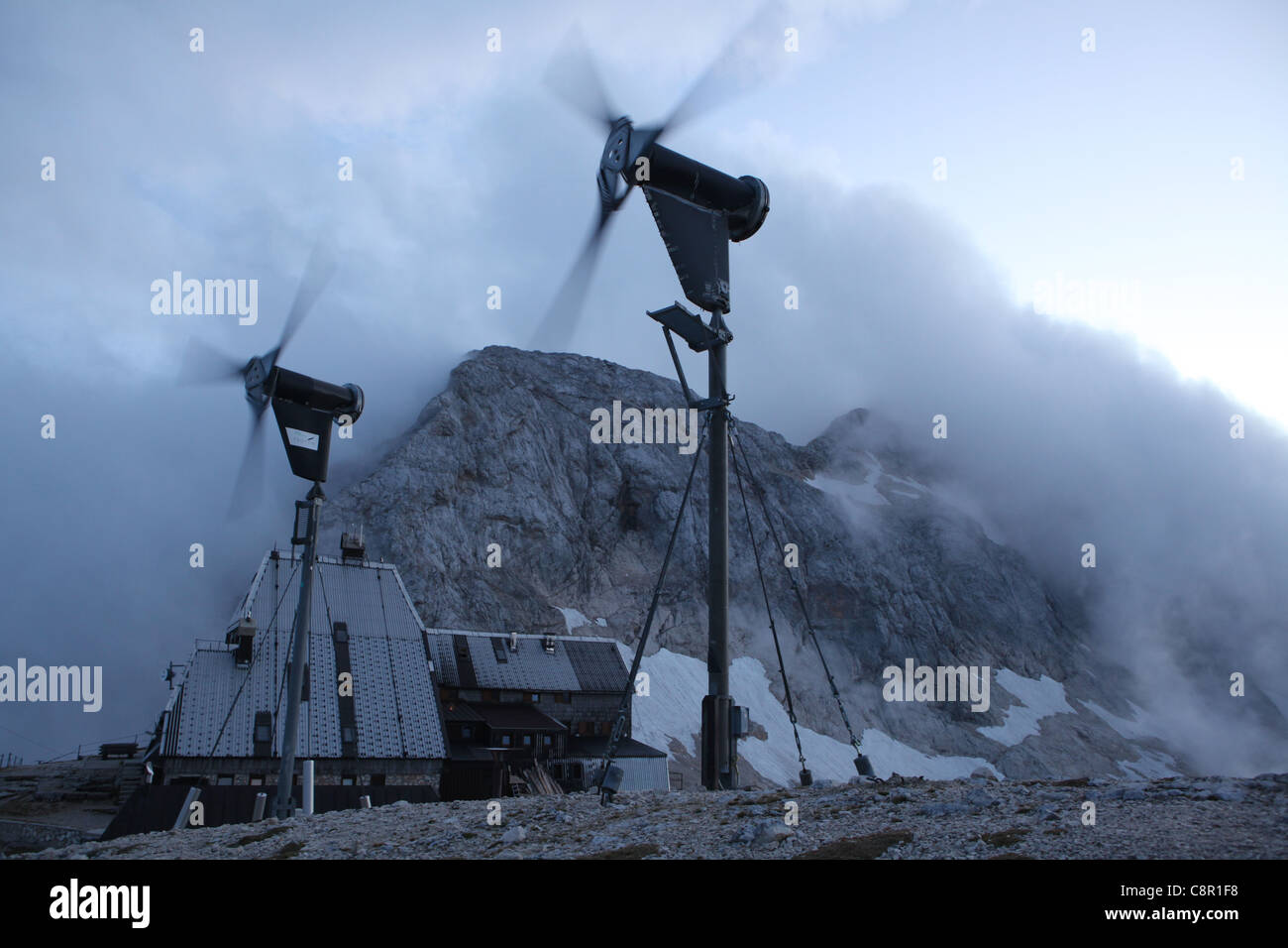 Wind farm and Triglavski dom mountain hut (2,515 m) at the foot of Mount Triglav (2,864 m) in the Julian Alps, Slovenia. Stock Photo