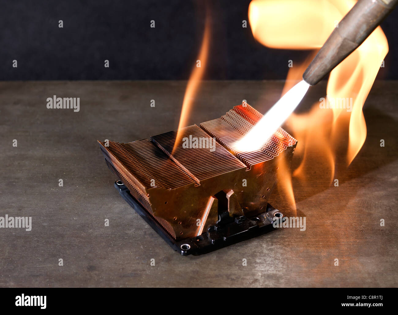 rundown CPU cooling element on metallic ground while burning with welding torch Stock Photo