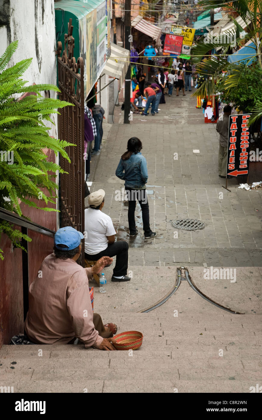 3 people looking down a street in Mexico. Stock Photo